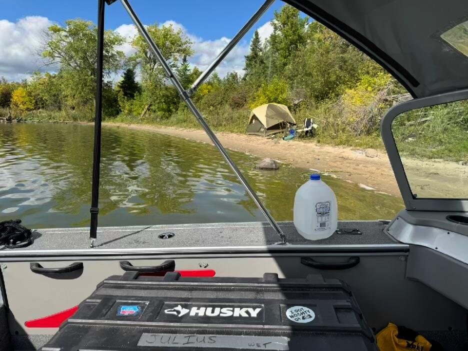 View from inside the boat toward a tent pitched on a sand beach