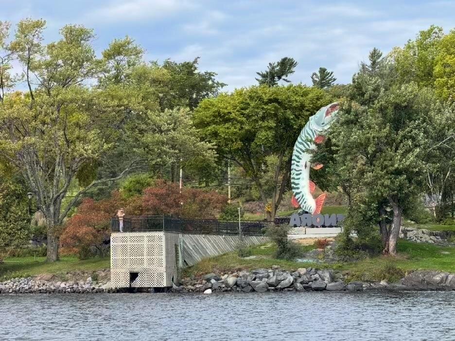Husky the Muskie, a large muskie statue standing on the Kenora waterfront beside a KENORA sign