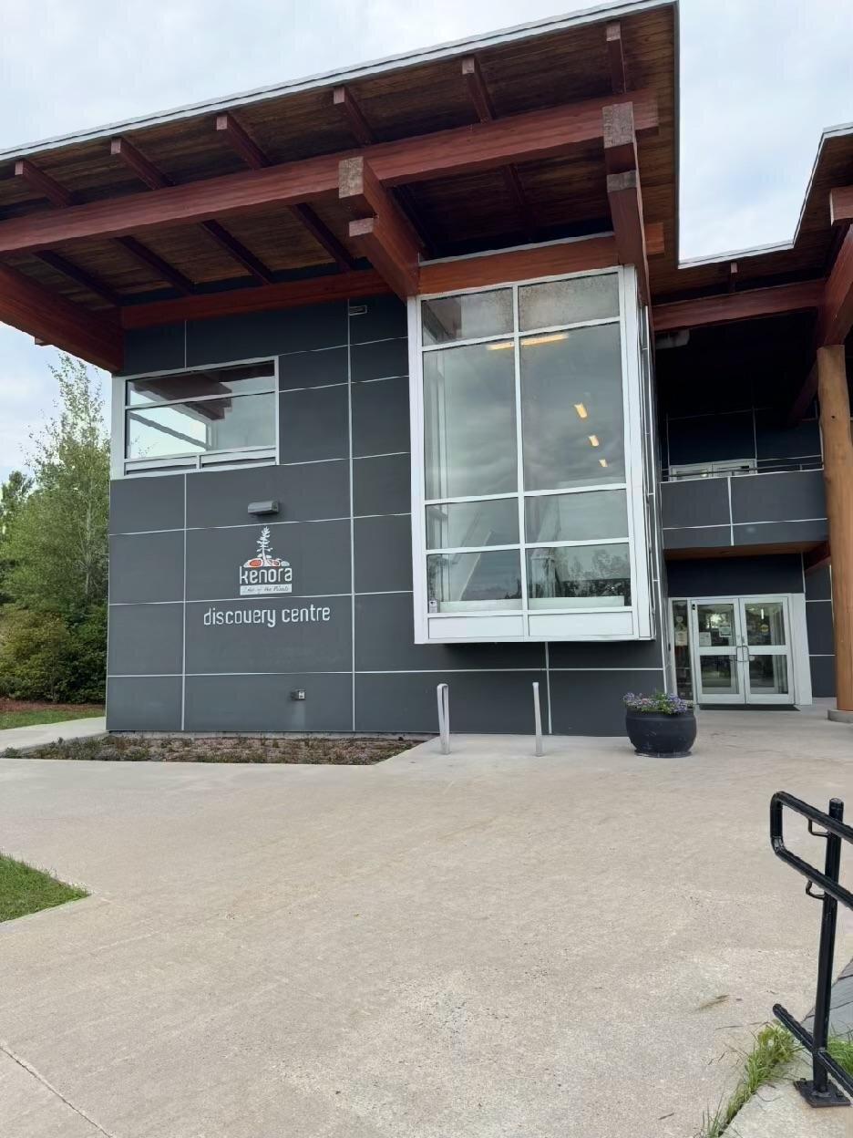 The entrance of the Kenora Discovery Centre, a dark-panelled building with heavy timber beams